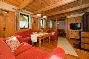 米尔施塔特Klieber - Urlaub am Biobauernhof的客厅配有红色的沙发和桌子