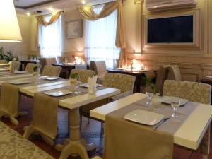 利沃夫Penthouse Apartment in Hotel Eney的餐厅设有桌椅和平面电视。