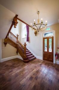 因弗内斯Rosedene Highland House Apartments, Central Inverness的一间带楼梯和吊灯的客厅