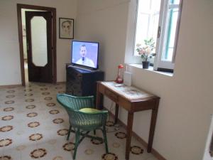 巴罗尼西Giardino degli aranci - Resort的客厅配有电视和桌椅