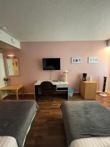 普达斯耶尔维hotelli ravintola kurenkoski的客房设有两张床和一台平面电视。