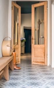 布鲁日B&B l'histoire de l'éclair的走廊设有木门,铺有瓷砖地板