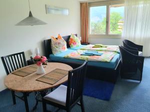 莫尔沙赫priv. Apartment bei Swiss Holiday Park的客房设有一张床和一张桌子及椅子