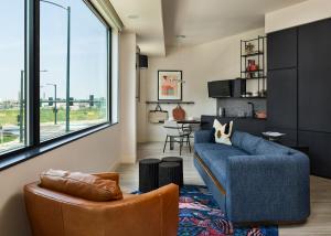 丹佛Catbird Hotel的客厅配有蓝色的沙发和两把椅子