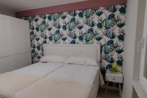 阿斯托加Los Sitios的卧室配有白色的床和花卉壁纸