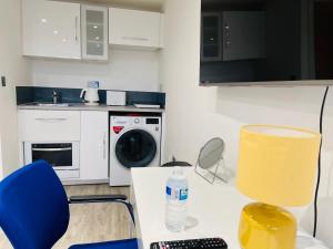 凯尼尔沃思NEW MODERN STUDIO APARTMENT, PARKING, Netflix的厨房配有桌椅和洗衣机。