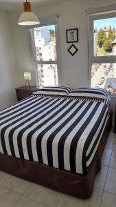 圣卡洛斯-德巴里洛切Bariloche Modern Apartment的卧室配有带条纹床和窗户
