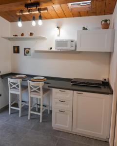 Bellisio di SopraLa Terrazza Azzurra的厨房配有带微波炉和凳子的台面