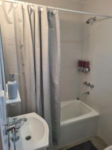 圣罗莎Andoli 2的浴室配有淋浴帘、浴缸和盥洗盆。