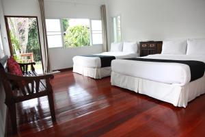 拜县RimPai Cottage的一间卧室设有两张床,铺有木地板