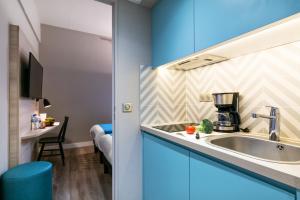 蒙彼利埃Appart'City Confort Montpellier Saint Roch的厨房配有蓝色橱柜和水槽