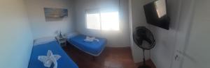 弗龙特拉Puestita de Sol的一间设有蓝色搁脚凳和窗户的客房