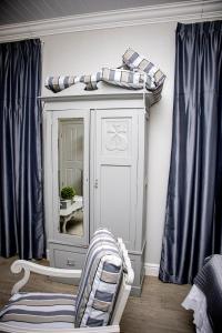 博福特西French Karoo Guesthouse的一间设有镜子、椅子和橱柜的房间