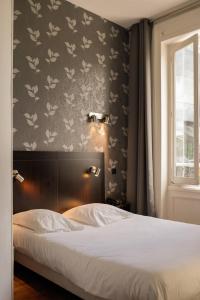 里尔拿破仑酒店的一间卧室设有一张床和鲜花墙