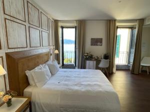 托尔诺Il Belvedere的一间带一张白色大床的卧室和一个阳台