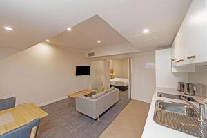 阿德莱德Quality Apartments Adelaide Central的厨房以及带沙发和床的客厅。