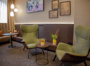 埃森Hotel Essener Hof; Sure Hotel Collection by Best Western的一间设有绿色椅子和桌子的等候室