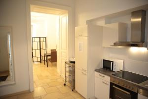 维也纳Heart of Vienna - City Apartment的厨房配有白色橱柜和微波炉