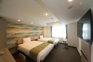 沼津Kuretake Inn Premium Numazu Kitaguchi Ekimae的配有绘画的酒店客房内的两张床