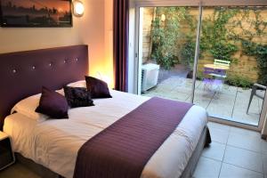 戛纳Villa Etoile Cannes的一间卧室配有一张带紫色枕头的大床