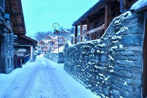 佩塞克鲁瓦The French Lodge的一条有石头墙和建筑的雪覆盖的街道