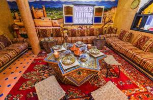 廷吉尔Riad Sephora的客厅配有沙发和餐桌,餐桌上摆放着餐具