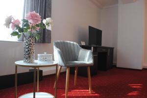 德罗贝塔-塞维林堡科罗娜酒店的一间房间,配有椅子和一张花瓶桌子