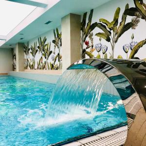 斯维诺乌伊希切Afrodyta Spa的一座位于酒店客房的带瀑布的游泳池