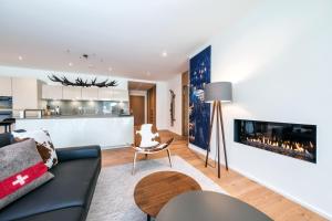 达沃斯Alpen panorama luxury apartment with exclusive access to 5 star hotel facilities的带沙发和壁炉的客厅