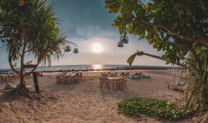 高兰The Lazy Lodge的海滩上设有桌椅,大海上设有沙滩