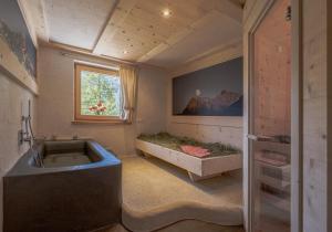 圣马蒂诺-因巴迪亚Ciasa Iachin Mountain Apartment的一间带大浴缸和窗户的浴室