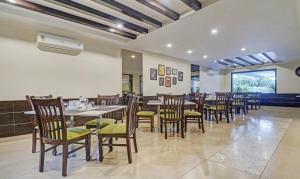 班加罗尔Treebo Tryst Raj Vista Global Village的餐厅内带桌椅的用餐室