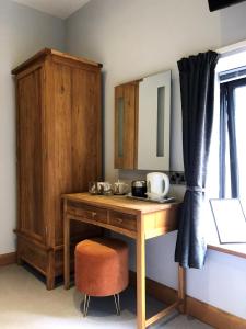 奥克姆Rutland Rooms的一张带椅子的木桌和橱柜