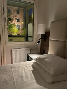 马尔默HOTEL N Hostel Malmö City的一间卧室设有一张床和一个大窗户