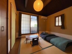 京都Guesthouse Nobi的客房设有床、桌子和窗户。