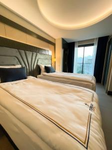 安塔利亚Türkay Hotel的配有大窗户的酒店客房内的两张床