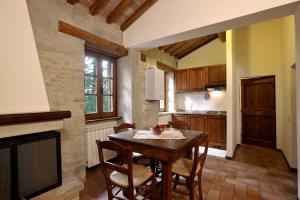 科尔恰诺Le Gorghe di Valmarino的厨房配有桌椅和壁炉。