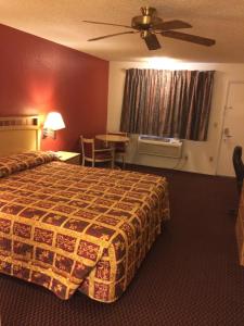 埃尔森特罗Value Inn & Suites的酒店客房配有一张床铺和一张桌子。