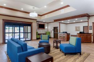 西门罗Comfort Suites West Monroe near Ike Hamilton Expo Center的客厅配有2把蓝色椅子和桌子