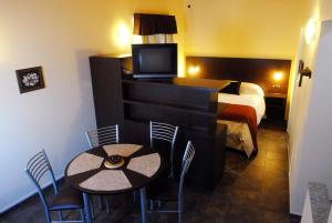 门多萨巴拉奇洛复式公寓的酒店客房带一张床、一张桌子和椅子