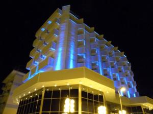 里米尼迪普罗玛皇宫酒店的上面有蓝色的灯的建筑