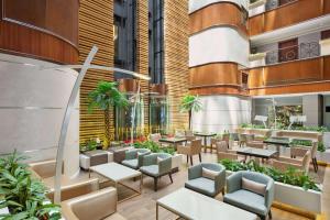 迪拜Howard Johnson Plaza by Wyndham Dubai Deira的大楼内带桌椅的餐厅