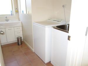 特威泽尔格莱斯顿小木屋度假屋的一个带水槽和洗衣机的小厨房