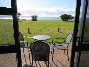 纳皮尔Harbour View Seaside Accommodation Napier的庭院配有桌椅,享有田野美景。