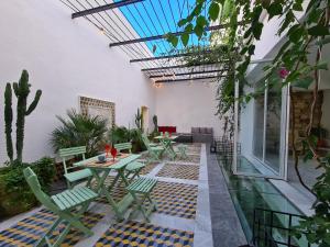 拉马萨Dar El Kif - La Marsa的户外庭院设有桌椅和植物