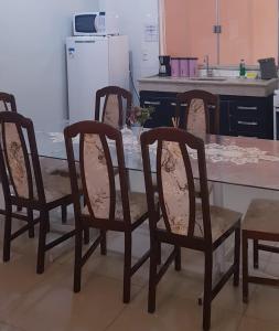 科伦巴Sobrado 2 amplo e confortável em condomínio的厨房配有带四把椅子的桌子和冰箱。