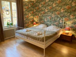SöderalaGramersgården的一间卧室配有一张带花卉壁纸的床