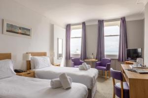 伊斯特布恩伯灵顿酒店的酒店客房配有两张床和紫色椅子