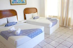 特克塞丁戈Hotel Ameyali Tequesquitengo的蓝色和白色的客房内的两张床