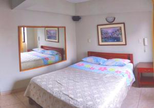 利马HOTEL GLAMOUR的一间卧室配有两张床和镜子